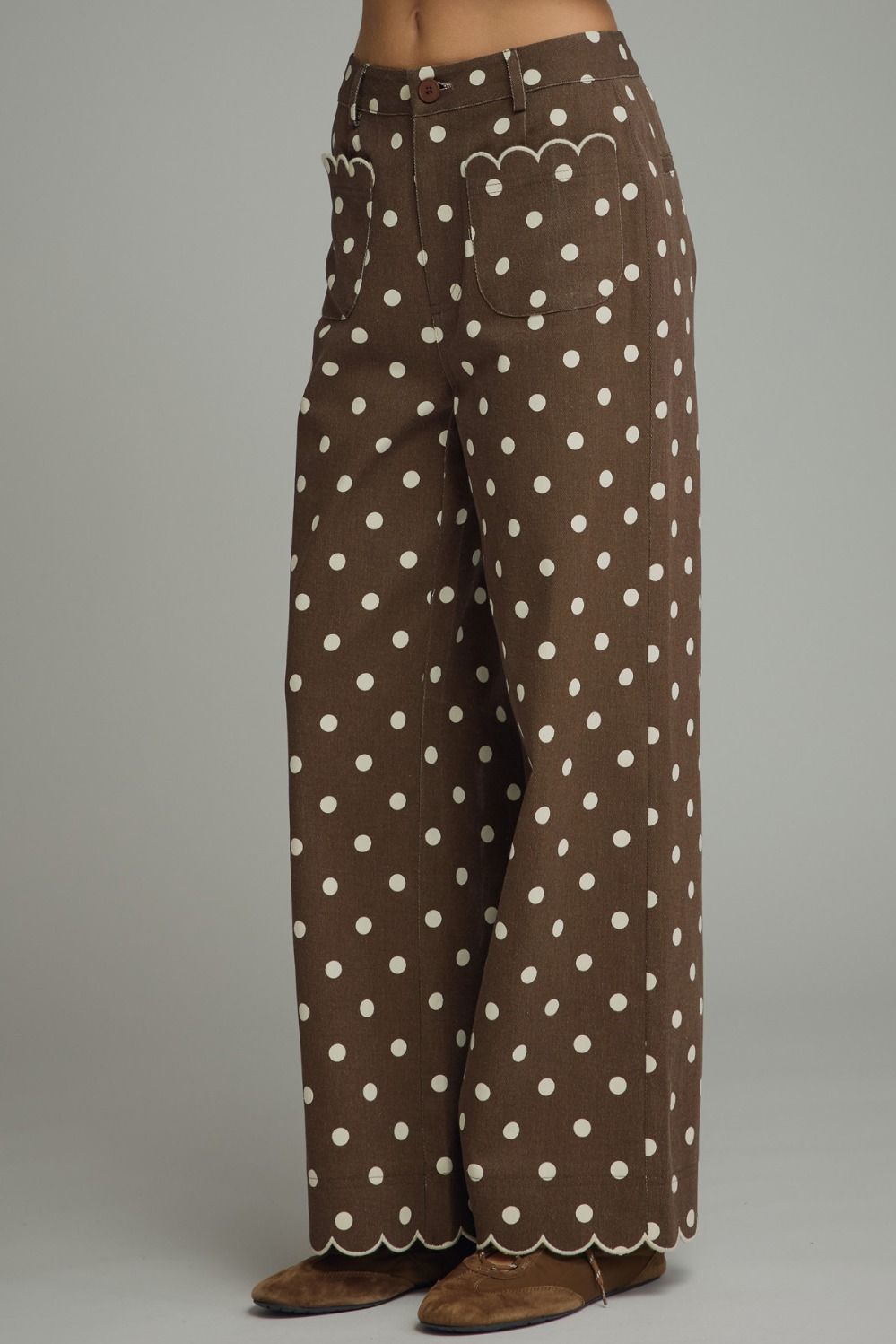 Brown polka dot wide leg pants front view with scalloped pockets and hem