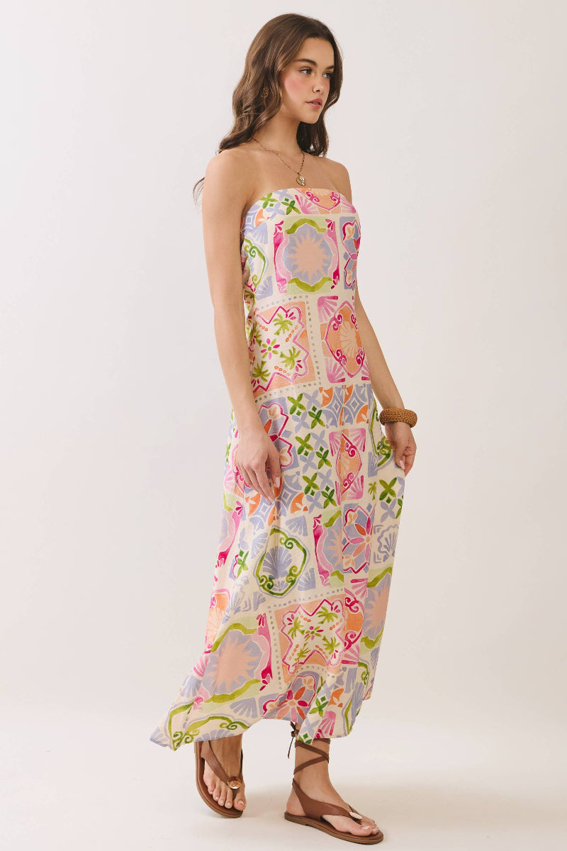 Woman wearing a colorful strapless dress with a pattern on a white background